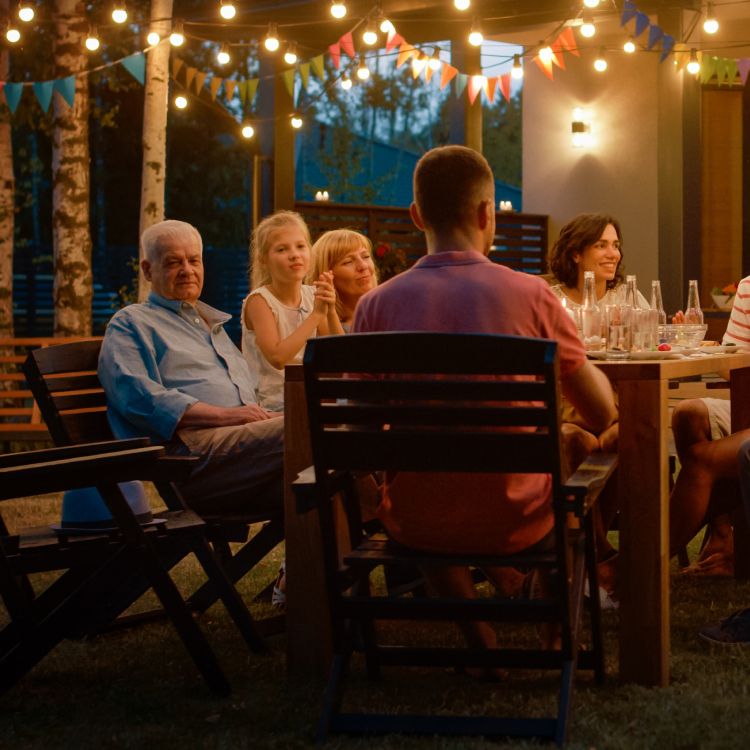 Photo of a group of friends, dining on a patio table in 2023