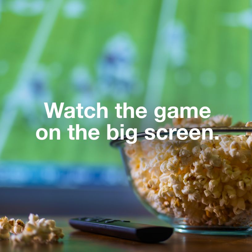 Watch the game on the big screen. Popcorn bowl in front of television.