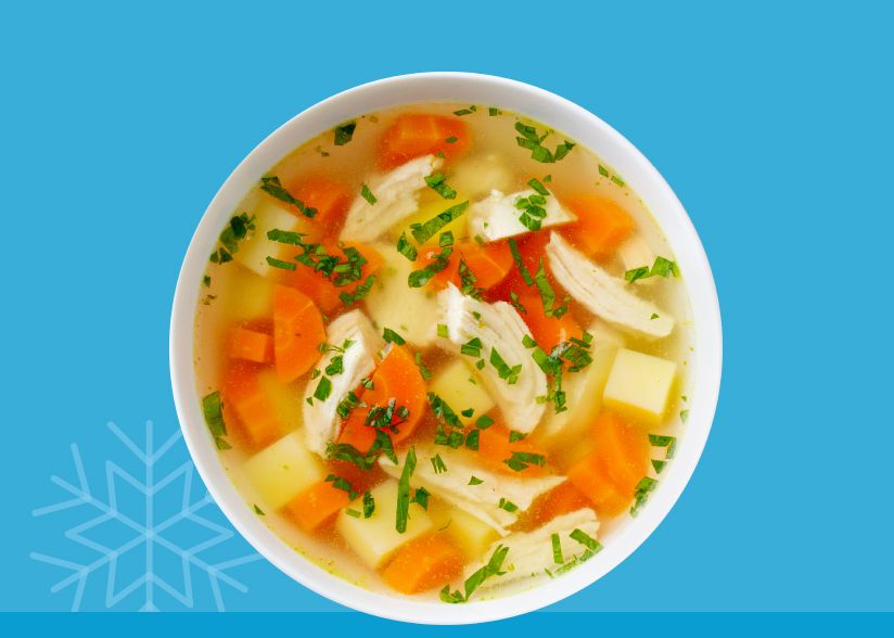 Image: A bowl of chicken noodle soup in front of a blue background