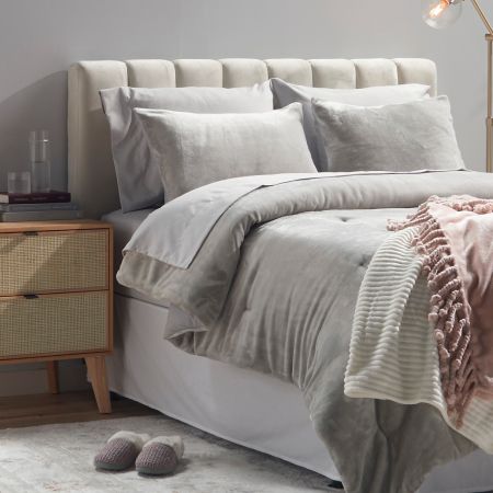 A bed with luxurious gray throw pillows, comforter and sheets