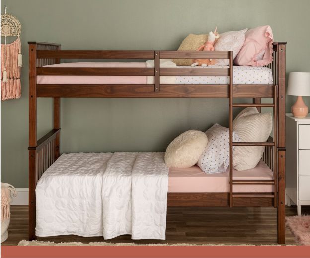 A wooden bunk bed set with pink sheets.