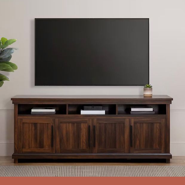 A tv mounted above a dark wood media center