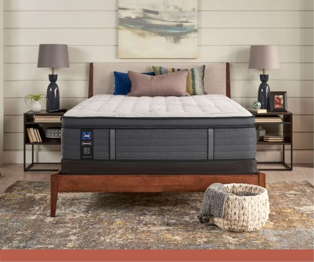 A bedroom set with a mattress without any covers on it.