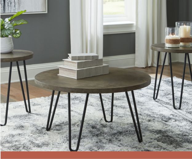 A round wooden coffee table with simple metal legs on a white marble patterned rug