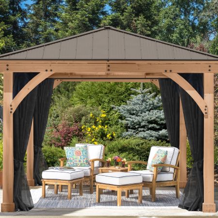 Two patio chairs with footrests under a wooden gazebo