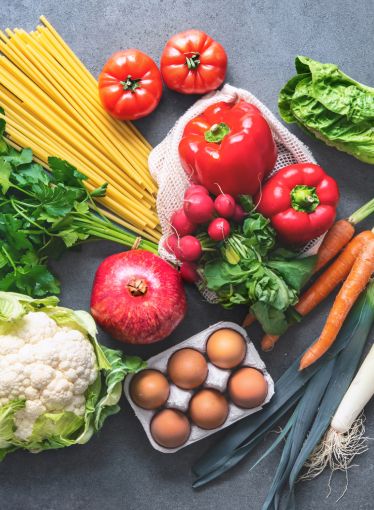 An assortment of fresh fruits, vegetables, pasta and eggs