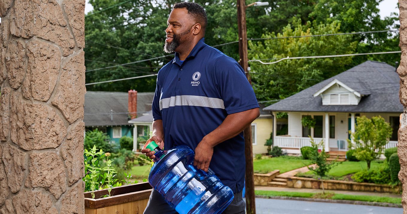 Image: Man holding water jug.