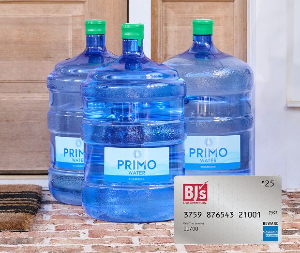 Two water jugs on top of a wooden table.
