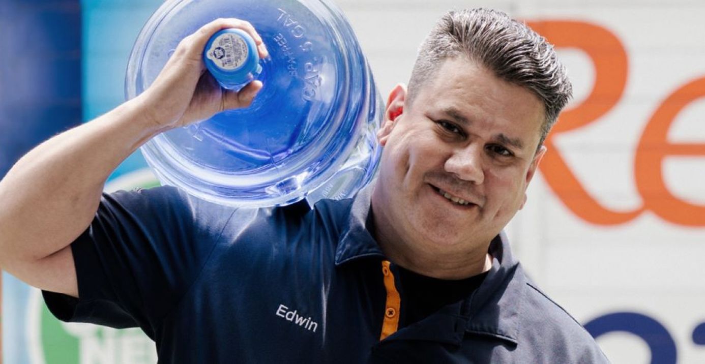 Image: Man holding water jug.